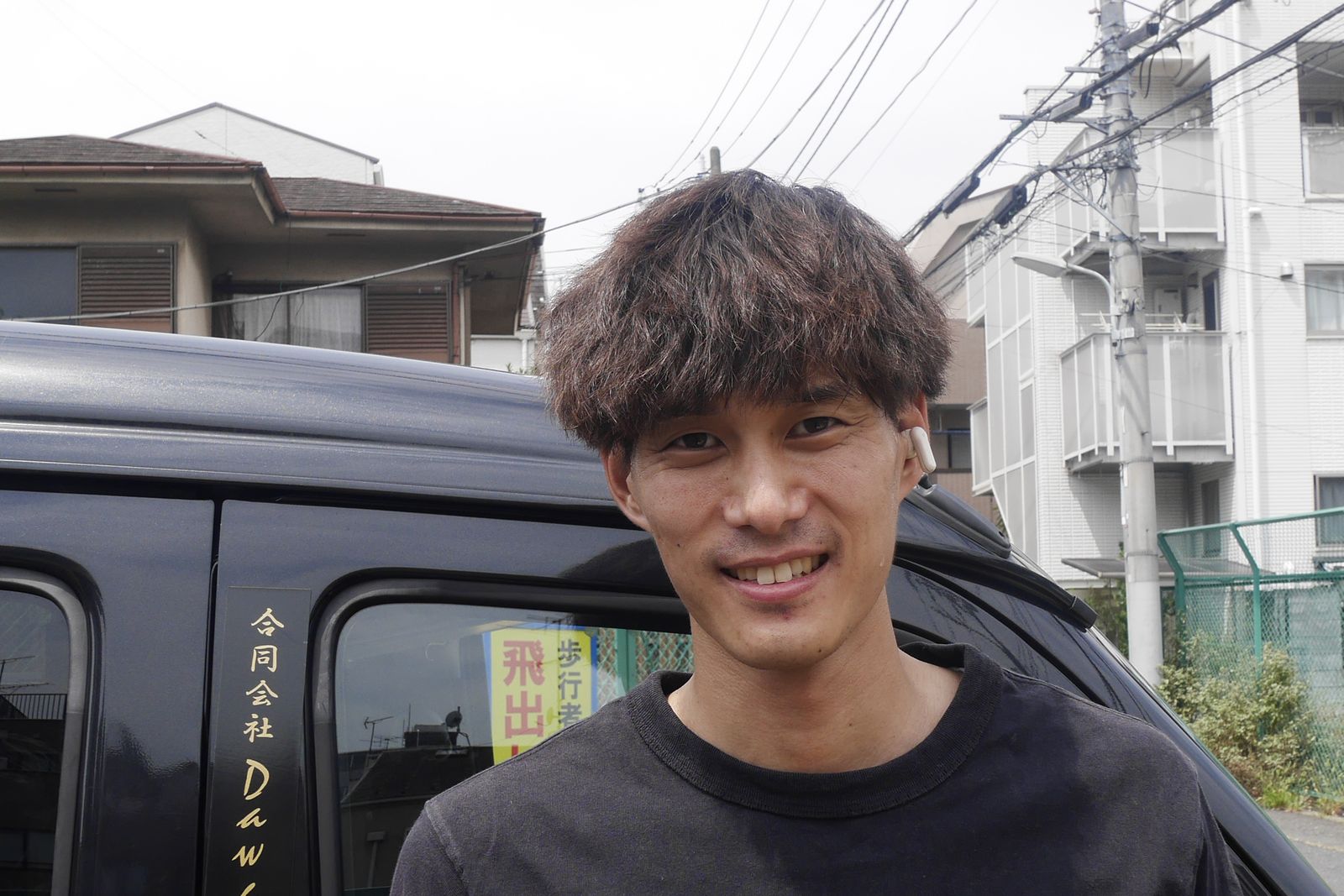 軽バンの前に立つドライバー